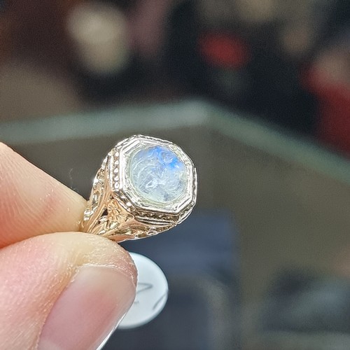 1217 - An Art Deco moonstone 'man in the moon' ring, unmarked gold settings with octagonal head and pierced... 