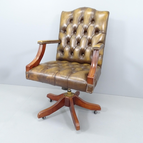 2165 - An early 20th century mahogany and button-back leather upholstered swivel lounge chair, with rise an... 