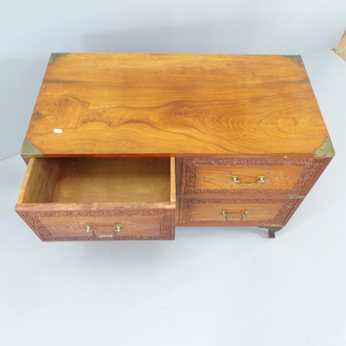 2166 - A Chinese camphorwood military style chest of four drawers, with brass mounts and carved decoration.... 