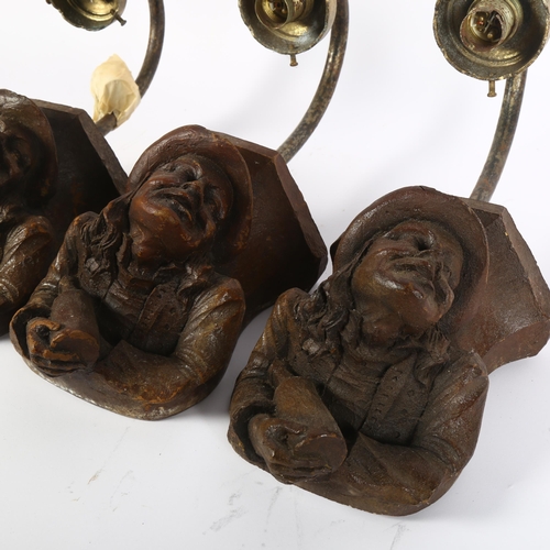 254 - A set of 3 painted composite wall sconces, supported by bottle carrying figures, overall height 34cm