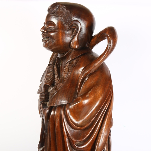 302 - A large carved hardwood study of a Chinese figure with a quill, height 76cm