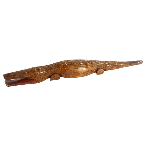 316 - A carved wood crocodile, incised to the underside L Comaroves 1951, length 90cm