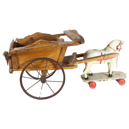 337 - An early 20th century painted wooden horse on wheeled base, 32cm, and an associated cart, cart lengt... 