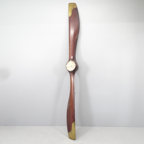 2205 - A large vintage aircraft propeller in mahogany with brass mounts, with inset clock. Length 250cm.