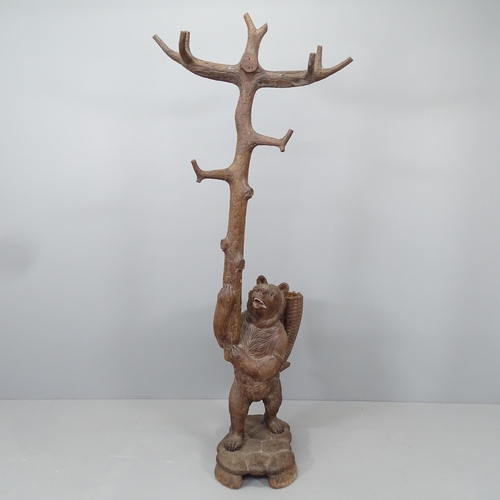 2207 - A large and impressive Black Forest hall stand in the form of a bear holding a branch, with hand pai... 