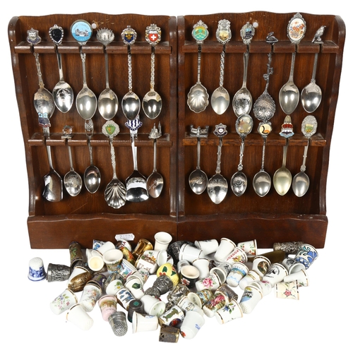 631 - A collection of porcelain and other thimbles, and 2 spoon racks with a collection of souvenir teaspo... 