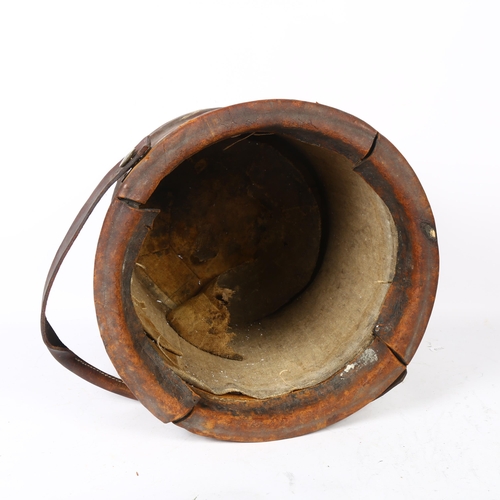 656 - An early 20th century canvas-lined leather-covered powder bucket, with swing handle, height 37cm