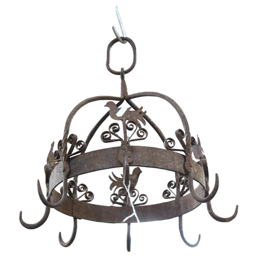 685 - A wrought-iron pan hanger with bird and floral decoration, 38cm across