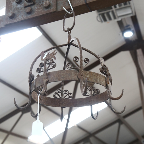 685 - A wrought-iron pan hanger with bird and floral decoration, 38cm across