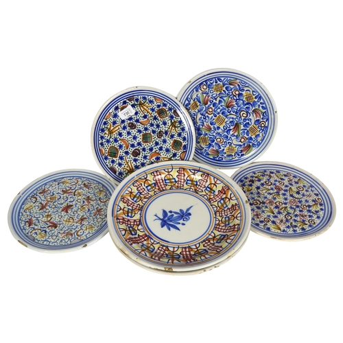 739 - A set of 4 tin glazed earthenware plates with painted decoration, 26.5cm, and 2 larger shallow dishe... 