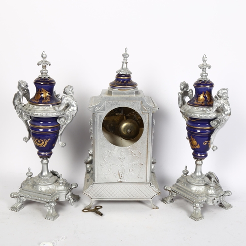 795 - A silvered brass and ceramic cased clock garniture, with figure and cherub decoration, lacking glass... 