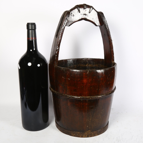 823 - A Chinese wooden well bucket, height 62cm, and a shop display Rioja Vega bottle