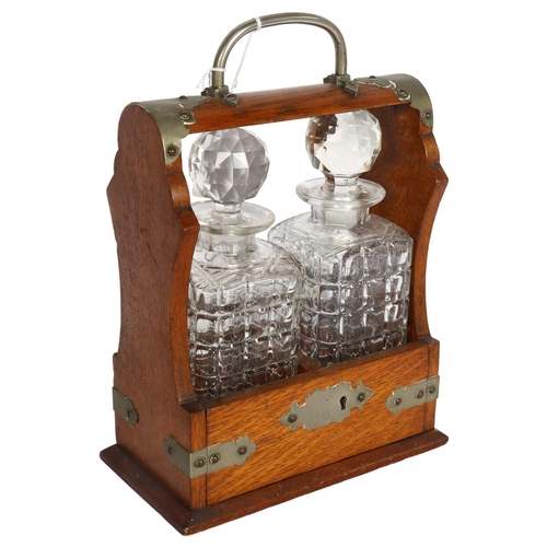 914 - An oak 2-bottle tantalus, with square section decanters, no key, W23cm, D13cm, H31cm