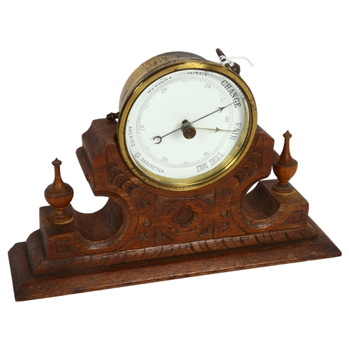 924 - A brass-cased aneroid barometer, maker's mark SJL & Co, on fitted Gothic oak base, width 22cm