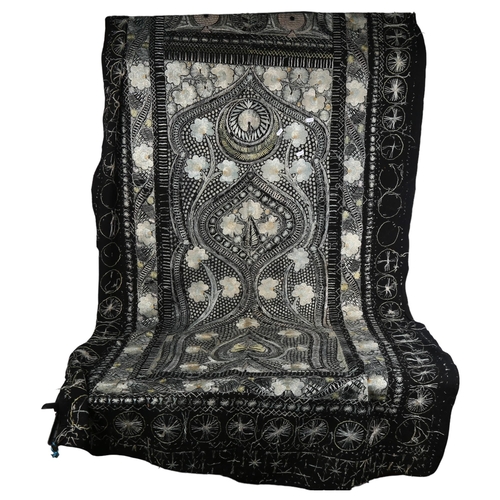 1034 - A black wool throw with embroidered floral decoration, 226cm x 110cm