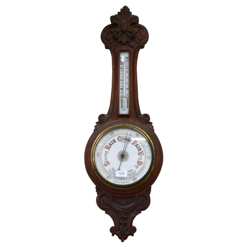 1055 - A Victorian carved oak-framed aneroid barometer, length 90cm