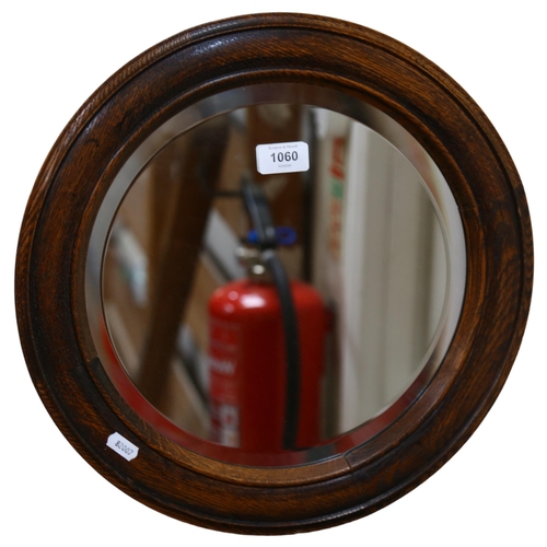 1060 - A circular oak-framed wall mirror, width 40cm