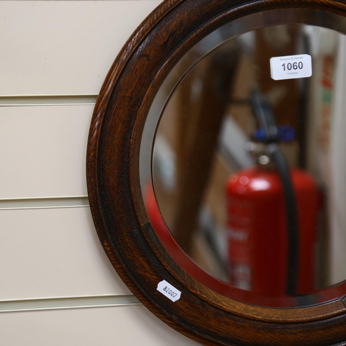 1060 - A circular oak-framed wall mirror, width 40cm