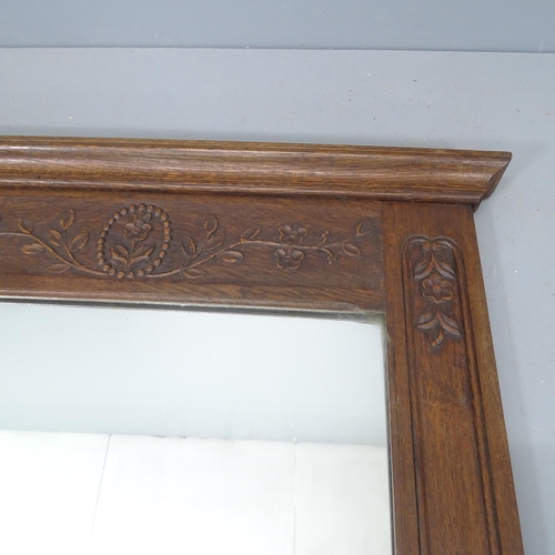 2220 - A French oak wall mirror, with applied carved decoration. 88x130cm