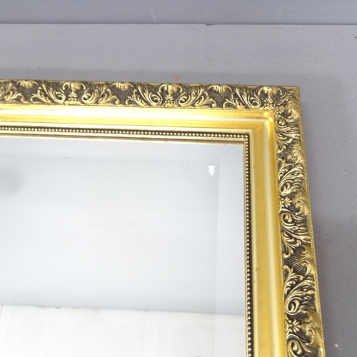 2221 - A modern gilt-framed wall mirror. 132x103cm