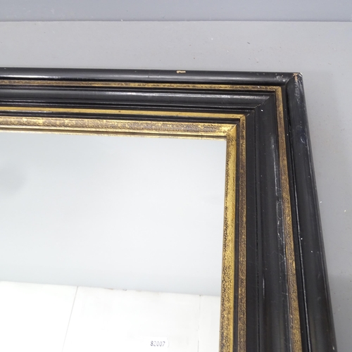 2222 - An ebonised and gilt-painted cushion framed wall mirror. 93x118cm