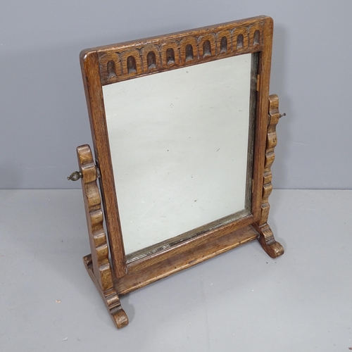 2229 - An early 20th century oak framed swing-toilet mirror with carved decoration. 43x50cm