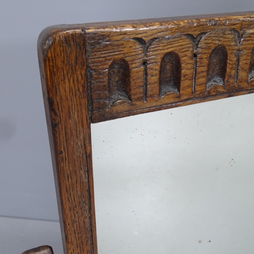 2229 - An early 20th century oak framed swing-toilet mirror with carved decoration. 43x50cm