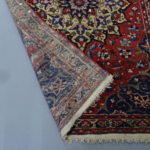 2294 - A red-ground Persian Sarouk rug. 202x138cm