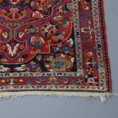 2295 - A red-ground Sarouk rug. 200x136cm