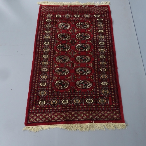 2329 - A red-ground Afghan rug. 132x80cm.