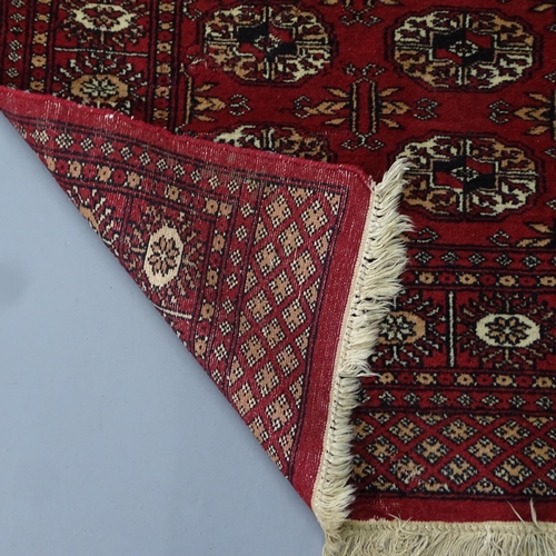 2329 - A red-ground Afghan rug. 132x80cm.