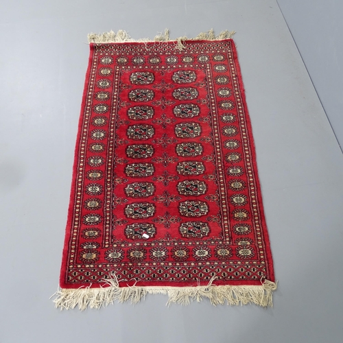 2330 - A red-ground Afghan rug. 126x80cm.