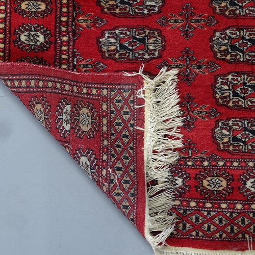 2330 - A red-ground Afghan rug. 126x80cm.