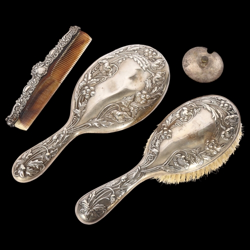 1111 - A matching Art Nouveau silver-backed dressing table brush and hand mirror, with embossed decoration,... 