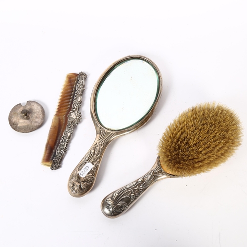 1111 - A matching Art Nouveau silver-backed dressing table brush and hand mirror, with embossed decoration,... 