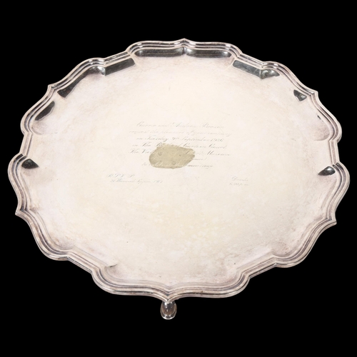 1123 - ASPREY - a silver plated salver of shaped form on 3 cast feet, bearing an inscription inviting the r... 