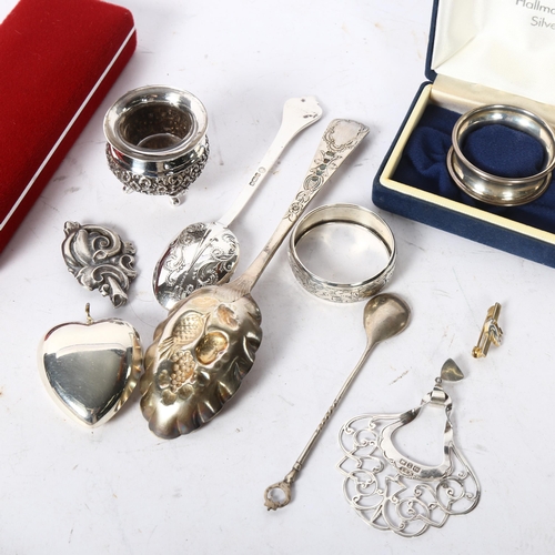 1202 - A tray of items to include a silver spoon and napkin ring, plated heart-shaped locket, plated salt e... 