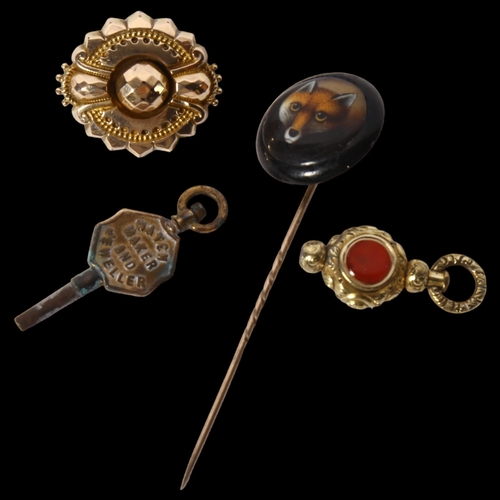 1208 - A gold-mounted fox design tie pin, gilt-metal stone set swivel fob, watch key, gilt-metal brooch