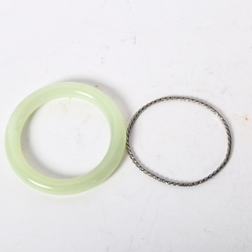 1216 - A green jadeite bangle, diameter 78mm, inside diameter 55mm, and a spiral bangle (2)