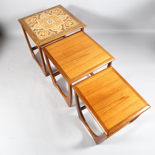 553 - A 1970's G-Plan nest of 3 tables, afromosia and teak construction with tile top to the largest table... 