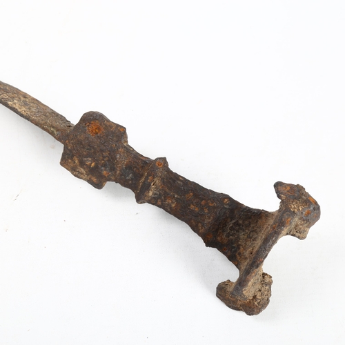 312 - ANTIQUITIES - a rare Iron Age sword with mask decorated pommel, length 68cm