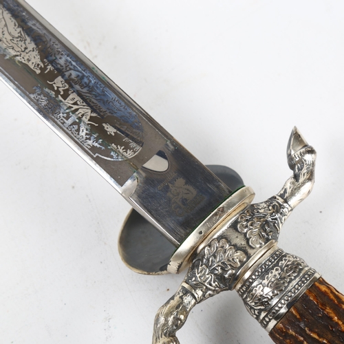 313 - A German Eickhorn Solingen hunting knife, the blade etched with a stag hunting scene, deer's hoof de... 