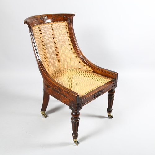 106 - An early 19th century simulated rosewood bergere tub chair in the manner of Gillows, carved show-woo... 