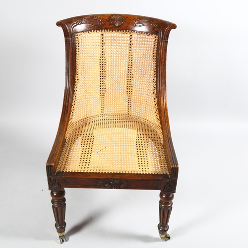 106 - An early 19th century simulated rosewood bergere tub chair in the manner of Gillows, carved show-woo... 