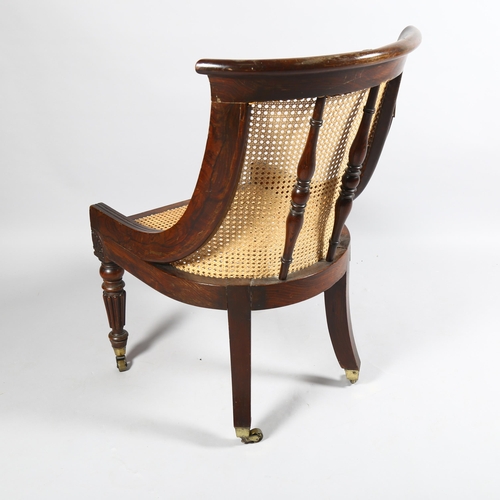 106 - An early 19th century simulated rosewood bergere tub chair in the manner of Gillows, carved show-woo... 