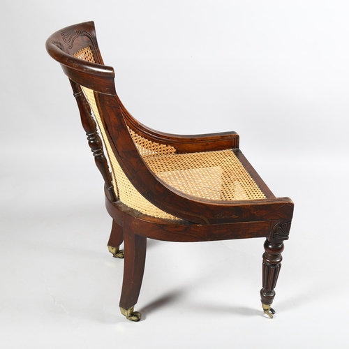 106 - An early 19th century simulated rosewood bergere tub chair in the manner of Gillows, carved show-woo... 