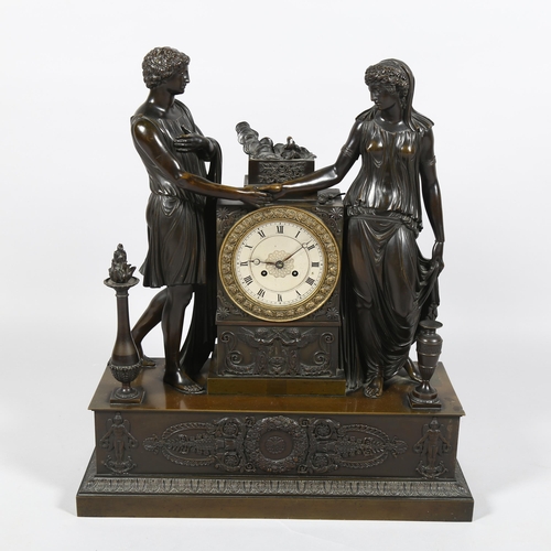 23 - A 19th century French patinated bronze-cased 8-day mantel clock, surmounted by Classical temple figu... 