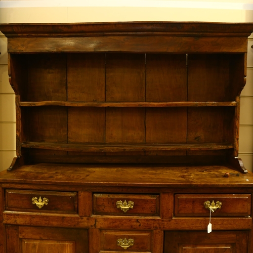 28 - An 18th century oak Welsh dresser, with boarded open plate rack above, 3 frieze drawers with 3 dummy... 