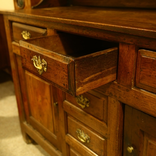 28 - An 18th century oak Welsh dresser, with boarded open plate rack above, 3 frieze drawers with 3 dummy... 