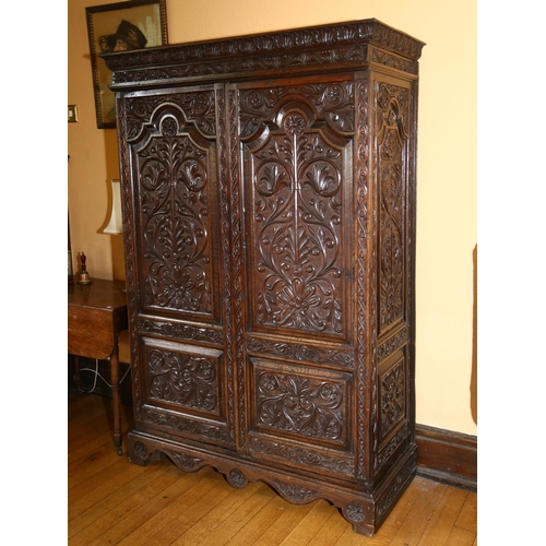 3 - An 19th century oak 2-door cupboard, with 2 heavily relief carved fielded panelled doors, carved and... 